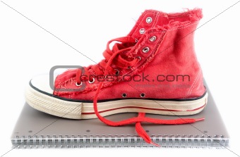 Red shoes on a school notebook. 