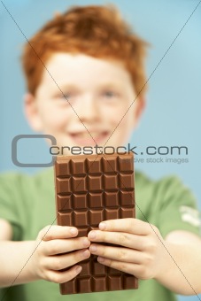 Young Boy Holding Bar Of Chocolate