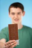 Teenage Boy Holding Bar Of Chocolate