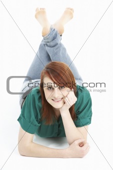 Portrait Of Smiling Teenage Girl Laying On Stomach