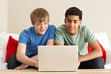Two Boys Using Laptop At Home
