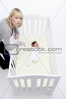Stressed Mother Looking At Baby In Cot