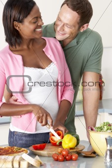 Young Couple Preparing Meal In Kitchen
