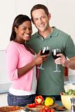 Young Couple Enjoying Glass Of Wine In Kitchen