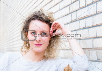 beautiful attractive young woman standing by white wall 