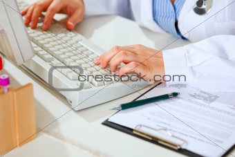 Close-up on hands of female medical doctor woman working at office table
