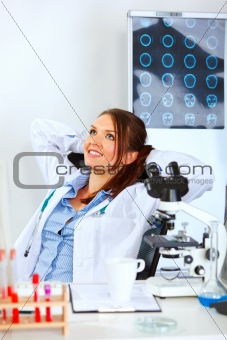 Doctor woman sitting at office table and relaxing
