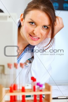 Portrait of attractive doctor woman looking out from monitor
