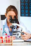 Female medical doctor using microscope in medical laboratory
