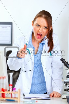 Angry doctor woman shouting and pointing on you
