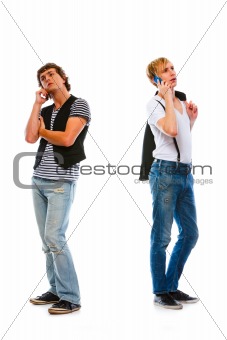 Two modern young men talking mobile. Isolated on white
