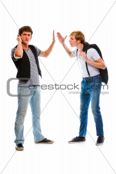 Young man with mobile showing wait gesture his indignant friend
