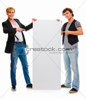 Two modern young men pointing on blank billboard. Isolated on white
