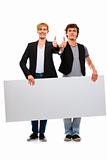 Two cheerful young men holding blank billboard and showing thumbs up
