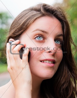 Outdoor portrait young woman talk on a cellular telephone 