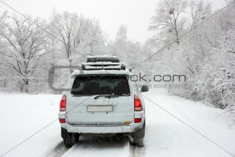 Snowy winter road behind an unrecognizable car