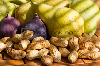 still life of fresh and fragrant peanuts, red figs, green pears