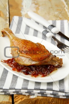 Roasted duck leg on white plate
