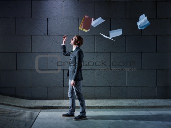 businessman throwing away files and documents