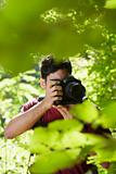 young male photographer hiking in forest 