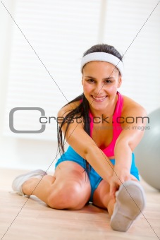 Smiling fitness woman making gymnastics exercise
