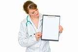 Medical female doctor showing blank clipboard
