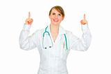 Smiling female medical doctor pointing up
