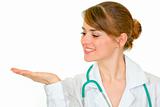 Smiling medical female doctor looking on empty palm
