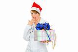 Surprised medical doctor woman in Santa hat looking on present box
