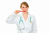Medical doctor woman with toothbrush showing how to clean teeth properly 
