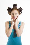 Young beautiful surprized woman in blue shirt with curlers