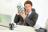 Interested businessman shaking present box trying to guess what's inside