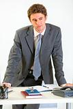 Portrait of thoughtful modern businessman holding hands on office desk
