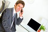 Successful businessman in office making phone call
