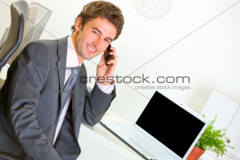 Successful businessman in office making phone call
