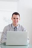 Close up of smiling businessman working on his laptop