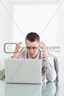 Businessman having problems with laptop
