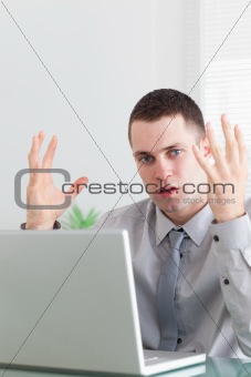 Close up of young businessman having problems with his notebook