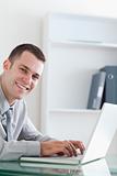 Happy businessman typing on his laptop