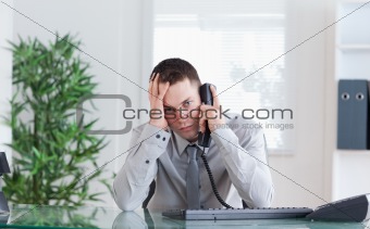 Businessman getting disappointing news on the phone