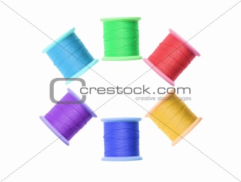 Few colorful thread bobbins isolated on white