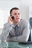 Businessman looking at the screen while listening to the caller
