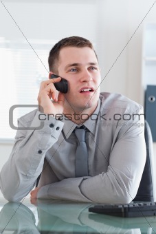 Businessman looking at the screen while listening to the caller