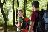 couple with backpack doing trekking in wood