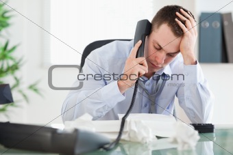 Businessman looking at an invoice while on the phone