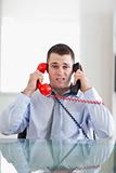 Businessman getting overextended by the telephone