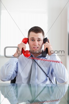 Businessman getting overextended by the telephone