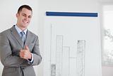 Businessman giving thumb up next to diagram