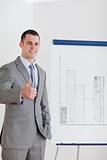 Businessman giving thumb up next to column graph