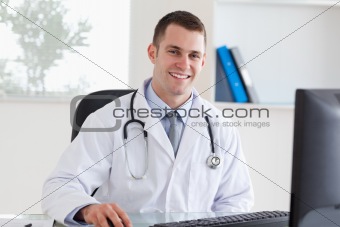 Smiling doctor on his computer